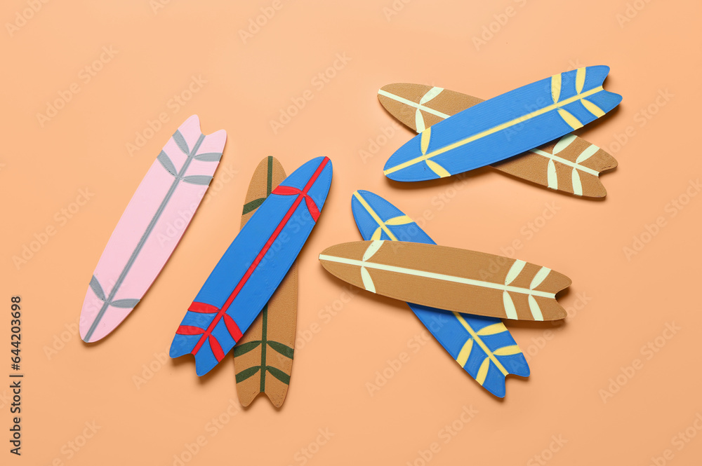 Different mini surfboards on orange background