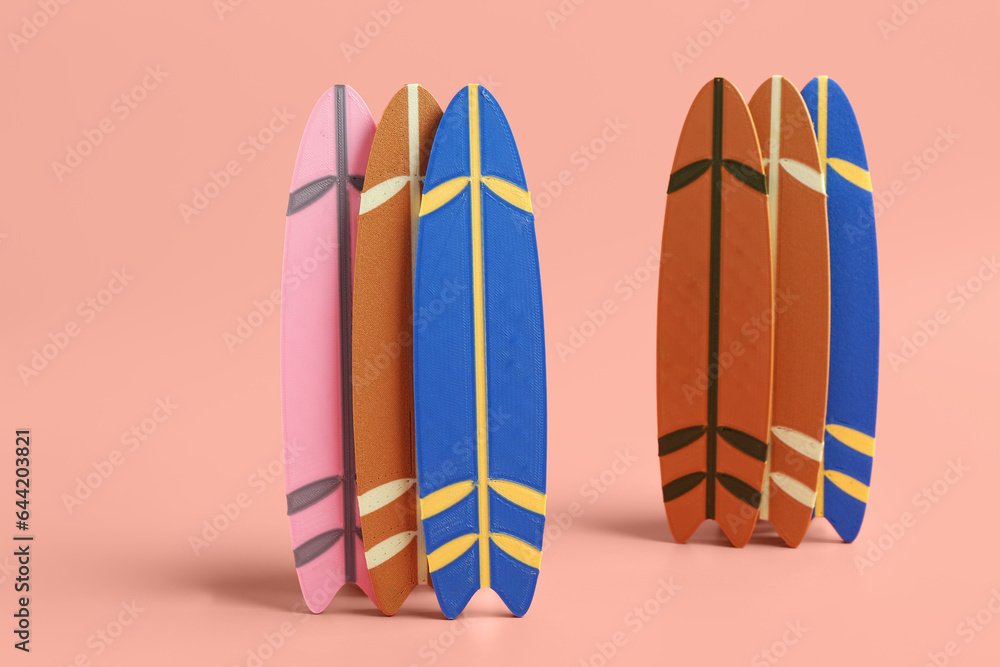 Different mini surfboards on pink background