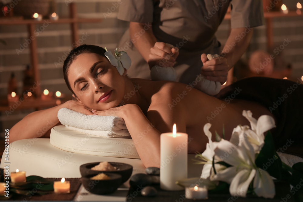 Young woman getting massage in dark spa salon, closeup