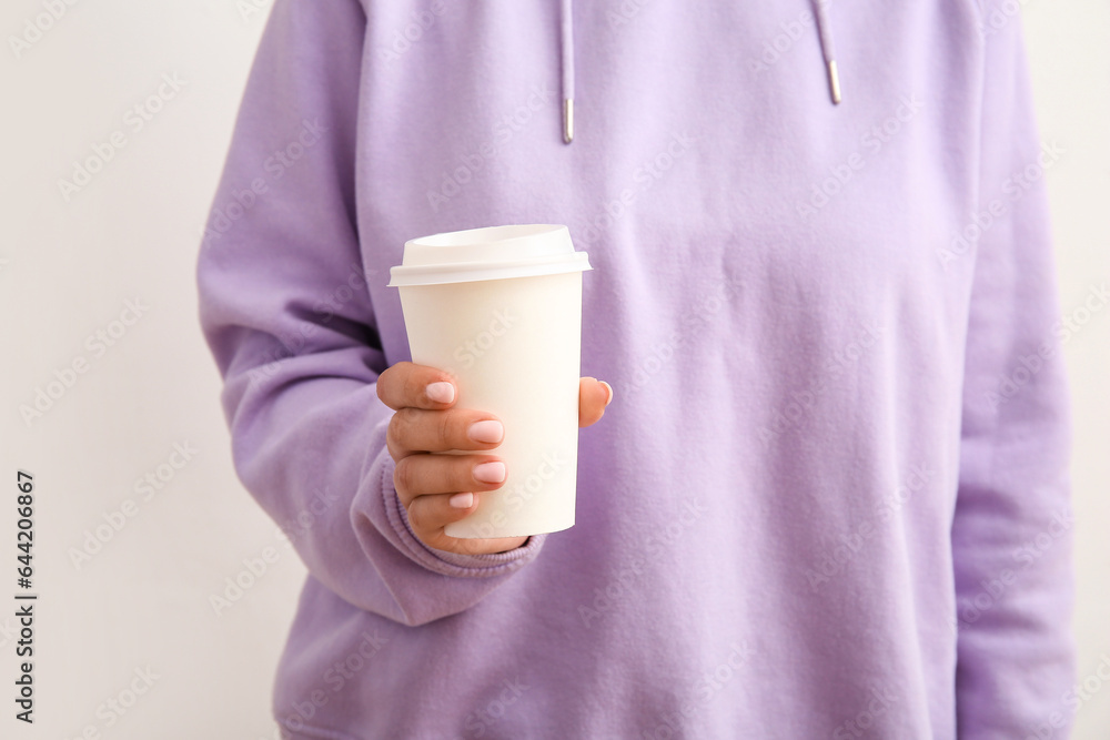 Woman with takeaway cup of hot coffee on white background