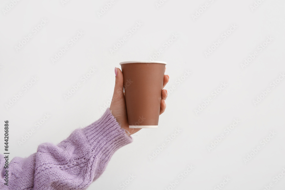 Woman with takeaway cup of hot coffee on white background