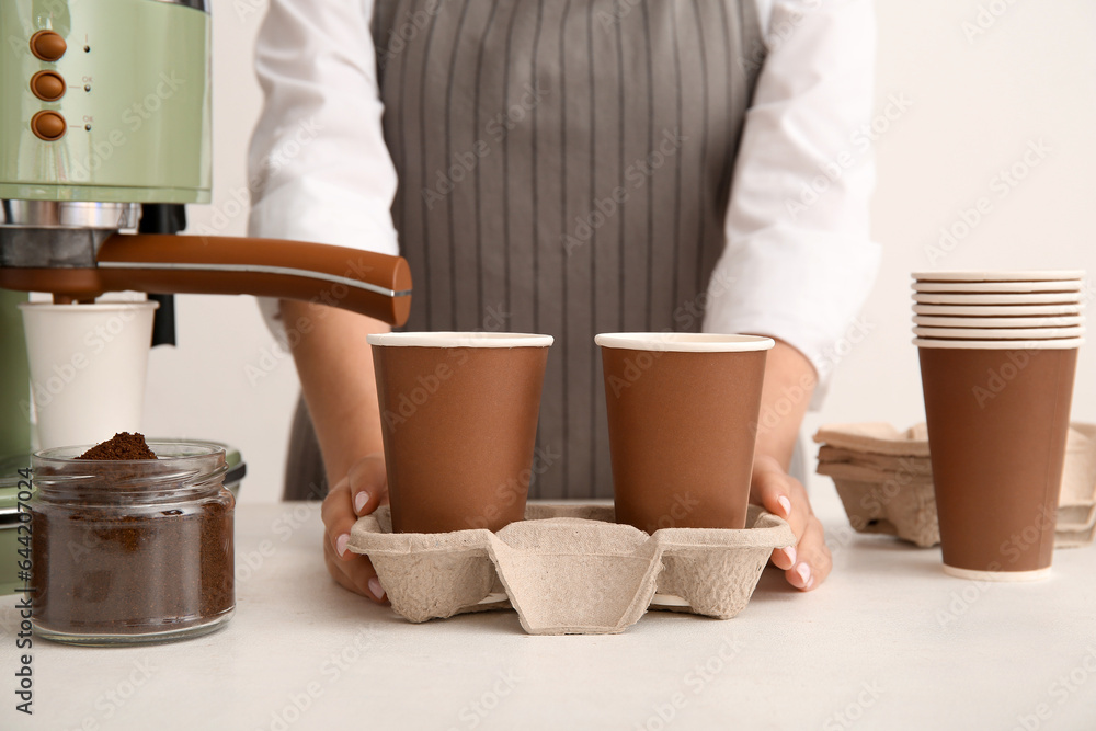 Woman with takeaway cups of tasty coffee on white background