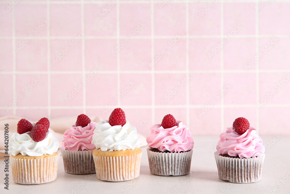 Tasty raspberry cupcakes on table