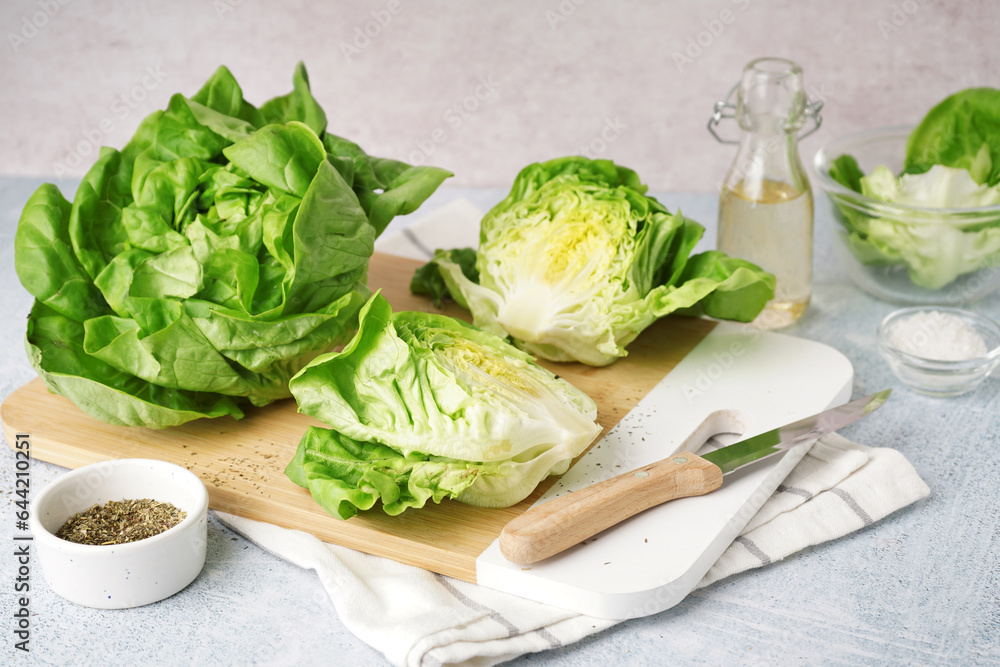 Wooden board with fresh Boston lettuce on white background