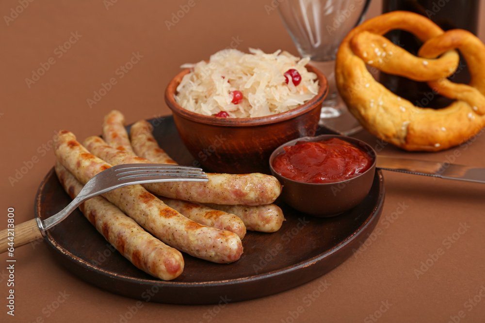 Plate with tasty Bavarian sausages, sauerkraut and sauce on brown background. Oktoberfest celebratio