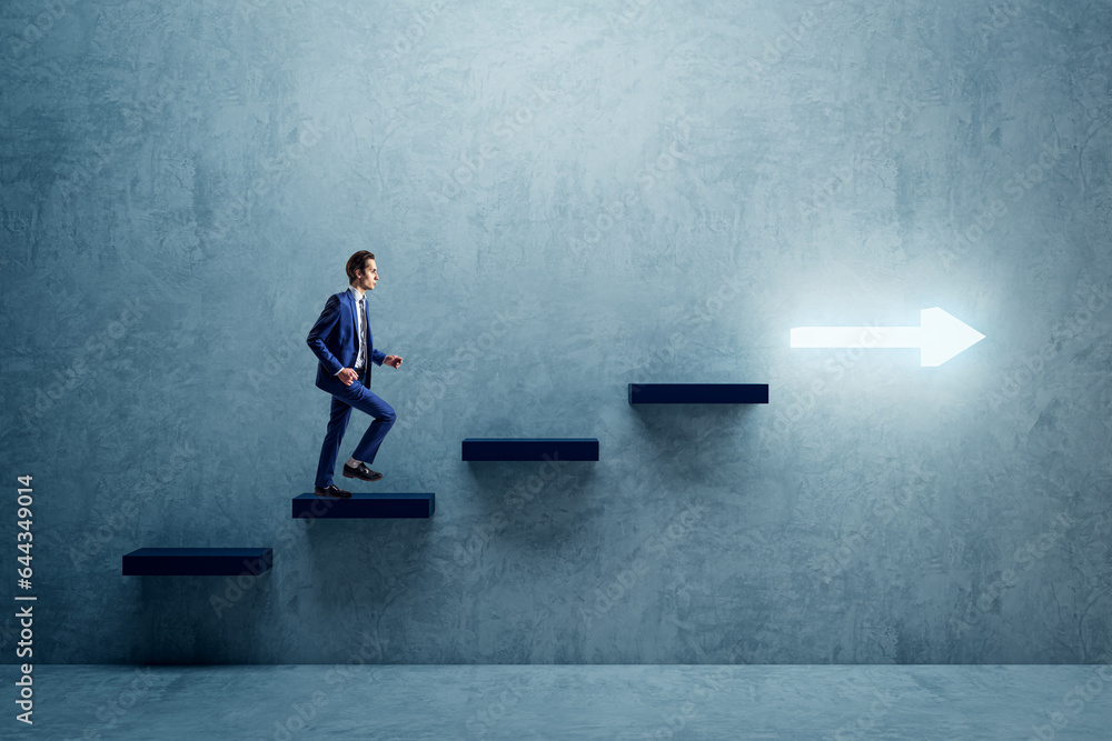 Side view of young businessman climbing illuminated arrow stairs to success on concrete wall backgro