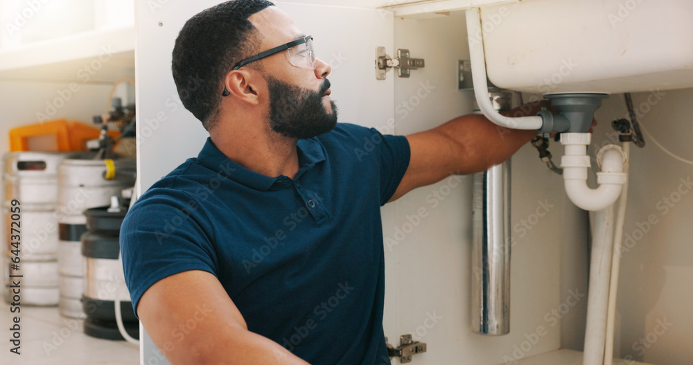 Plumber black man, kitchen and sink maintenance with tools, focus and pipe repair for drainage in ho