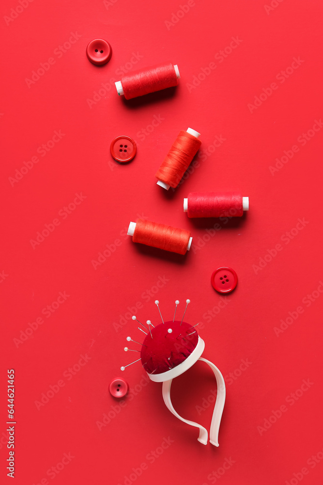 Composition with sewing supplies on red background