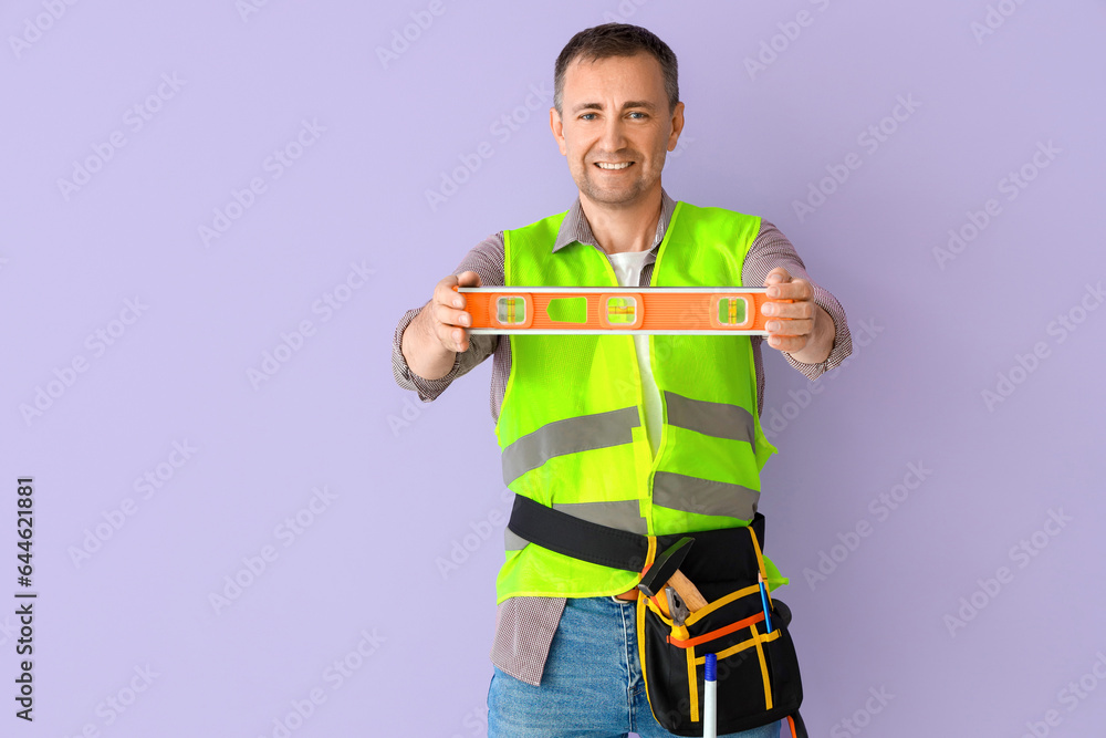 Mature builder with level on lilac background