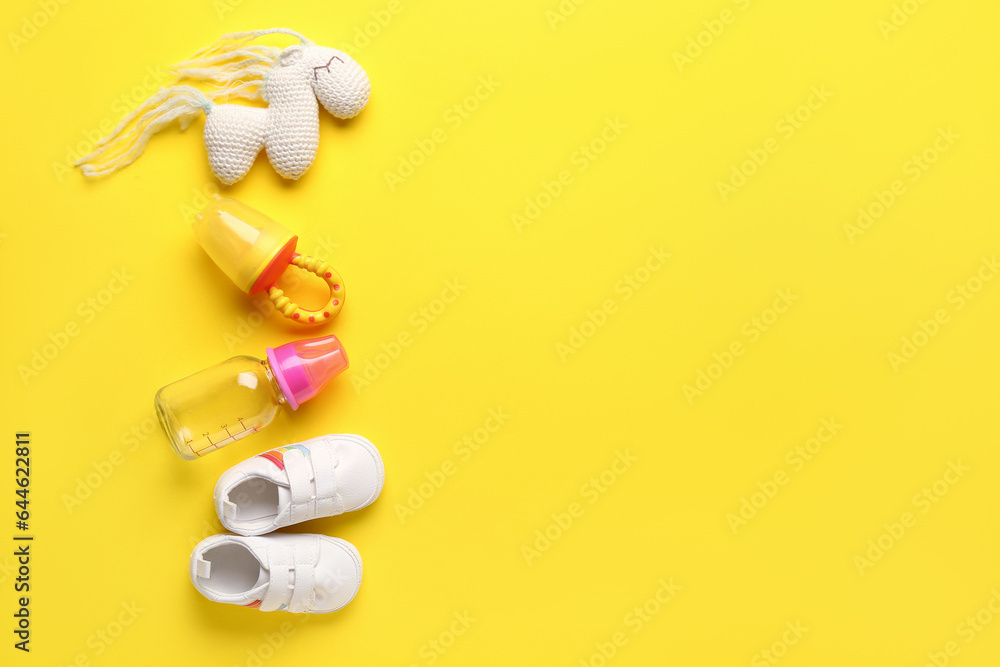 Set of baby accessories on yellow background