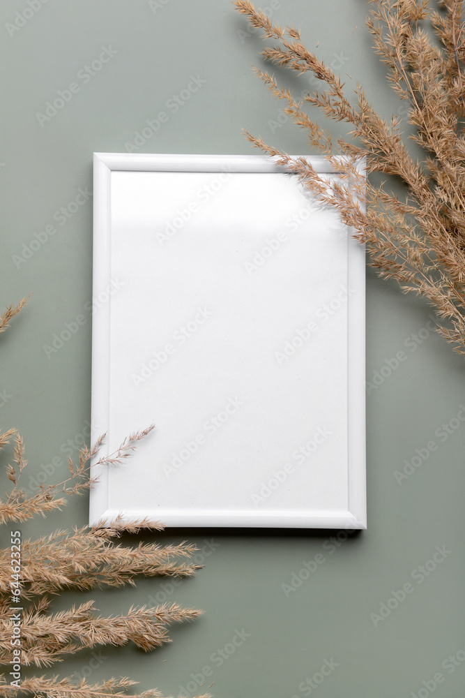 Blank picture frame with pampas grass on green background