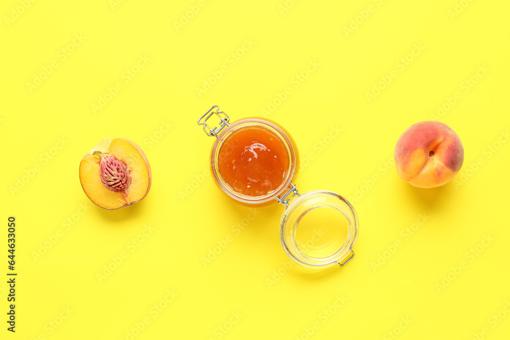 Glass jar of sweet peach jam and fresh fruits on yellow background