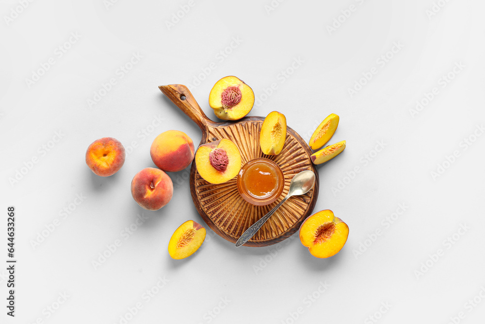 Wooden board with jar of tasty peach jam and fresh fruits on light background