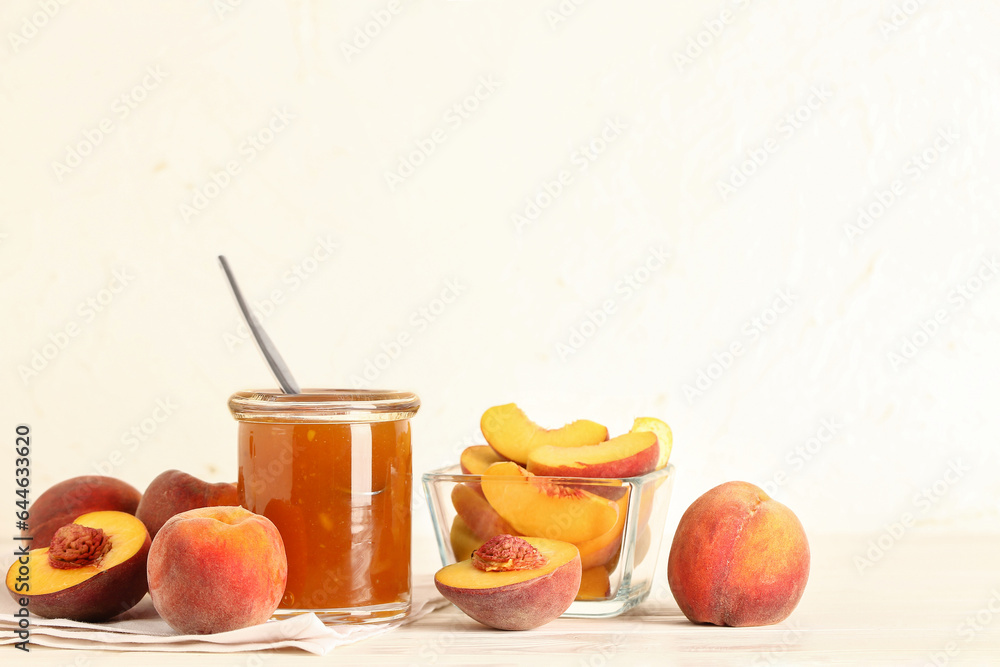 Jar with sweet peach jam and fresh fruits on table