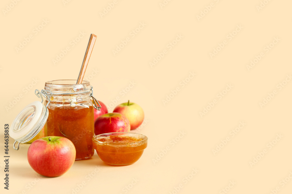 Jar and glass bowl of sweet apple jam on orange background