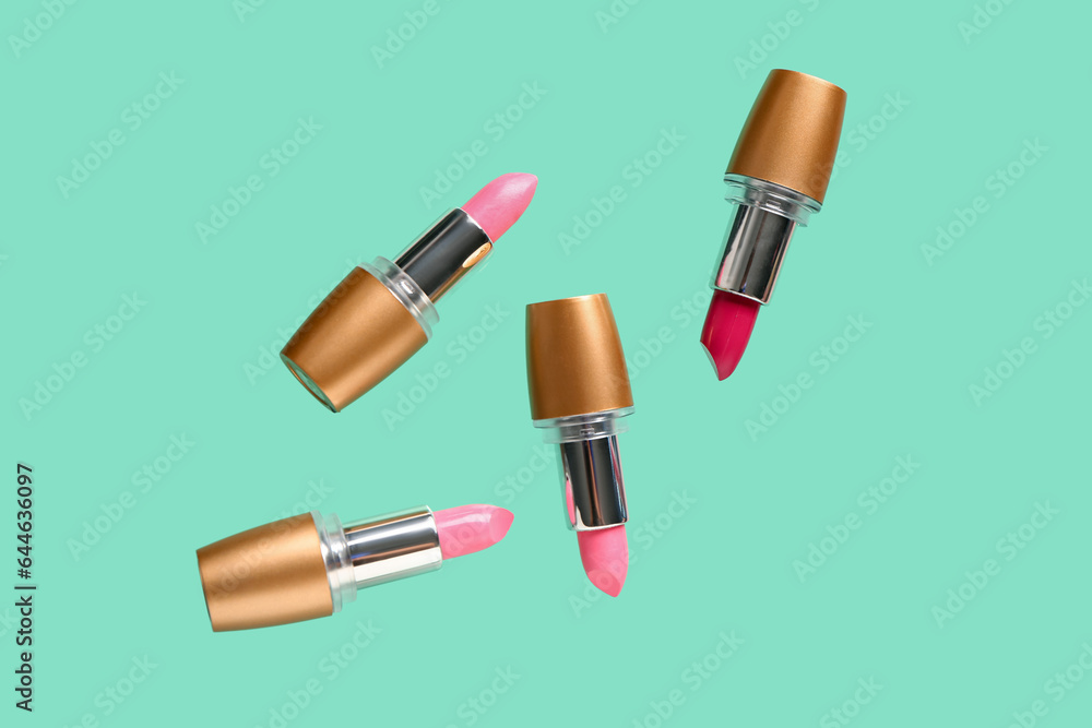 Beautiful lipsticks flying on color background