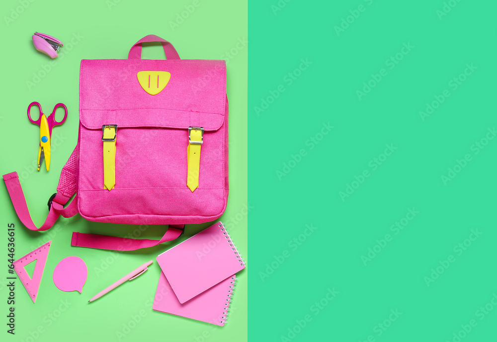 Composition with pink school backpack and stationery on green background