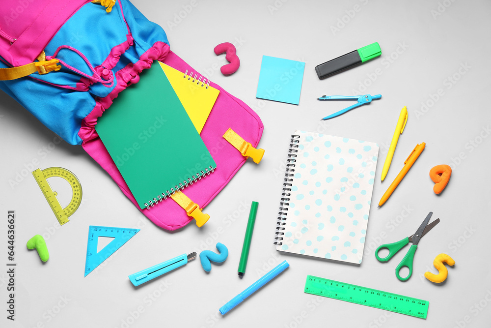 Composition with stylish school backpack and different stationery on grey background