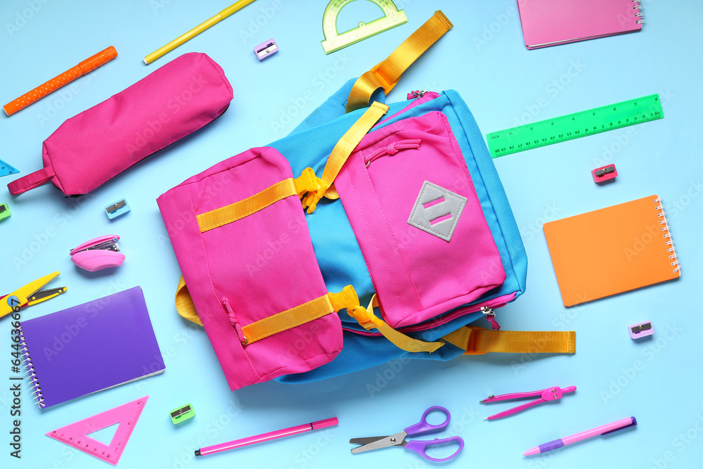 Composition with different stationery and school backpack on color background