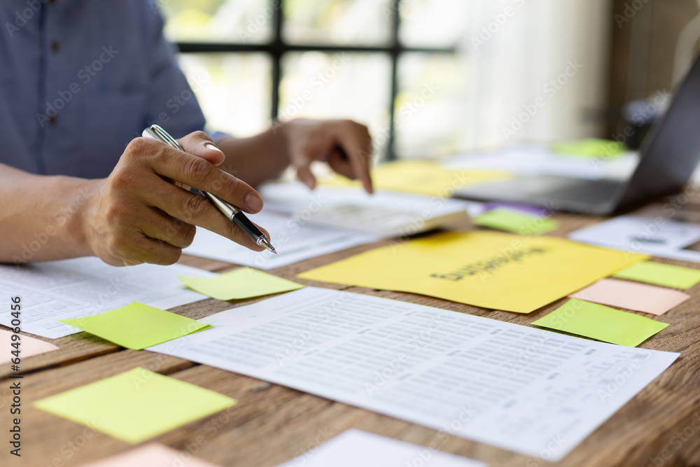 Man working on paperwork on desk, planning marketing business in office.