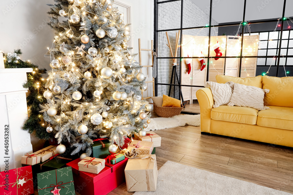 Interior of living room with Christmas tree, yellow sofa and folding screen