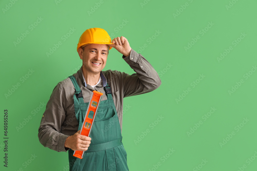 Mature builder with level on green background