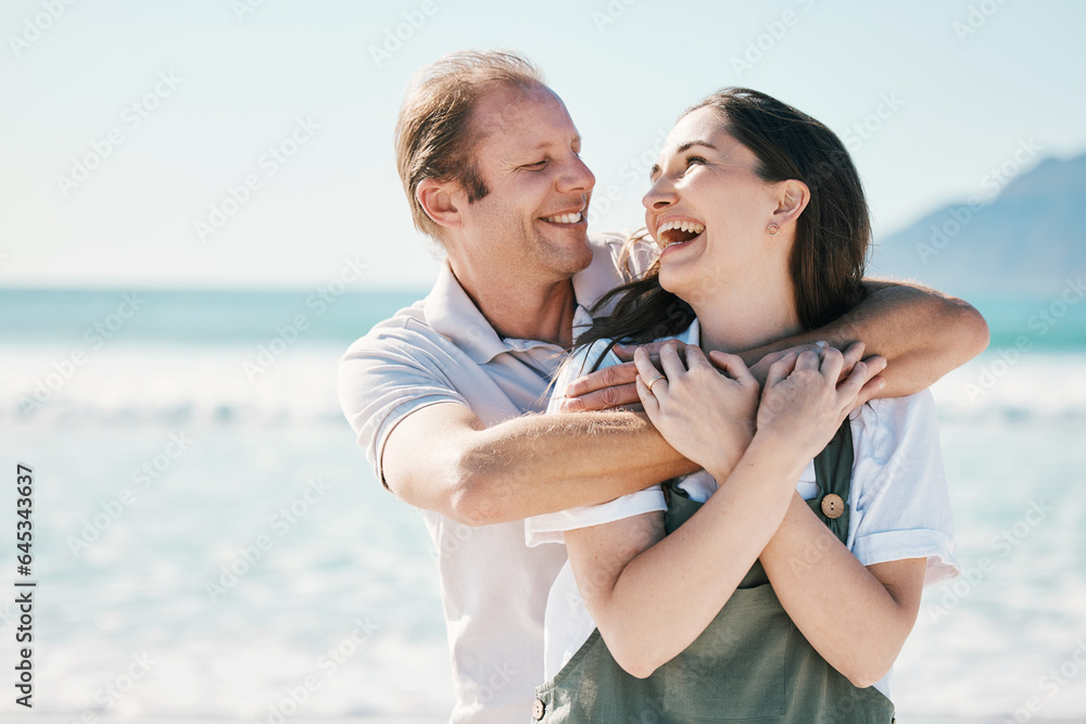 Happy, couple and hug by the sea with love, laughing and bonding on vacation at ocean. Summer, roman