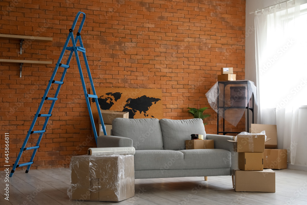 Sofa with cardboard boxes in living room on moving day