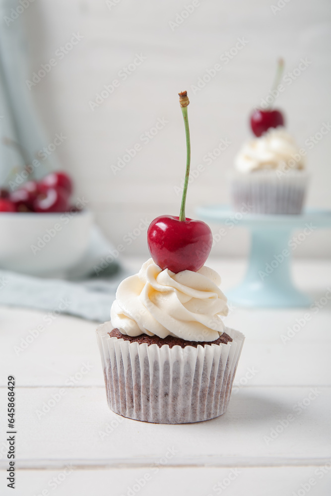 Tasty cherry cupcakes on table