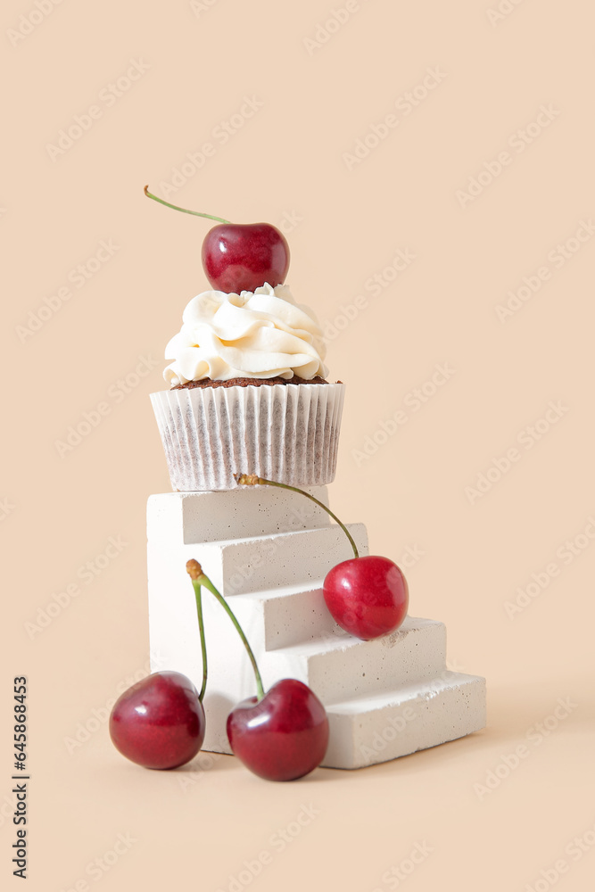 Decorative stand with tasty cherry cupcake on beige background