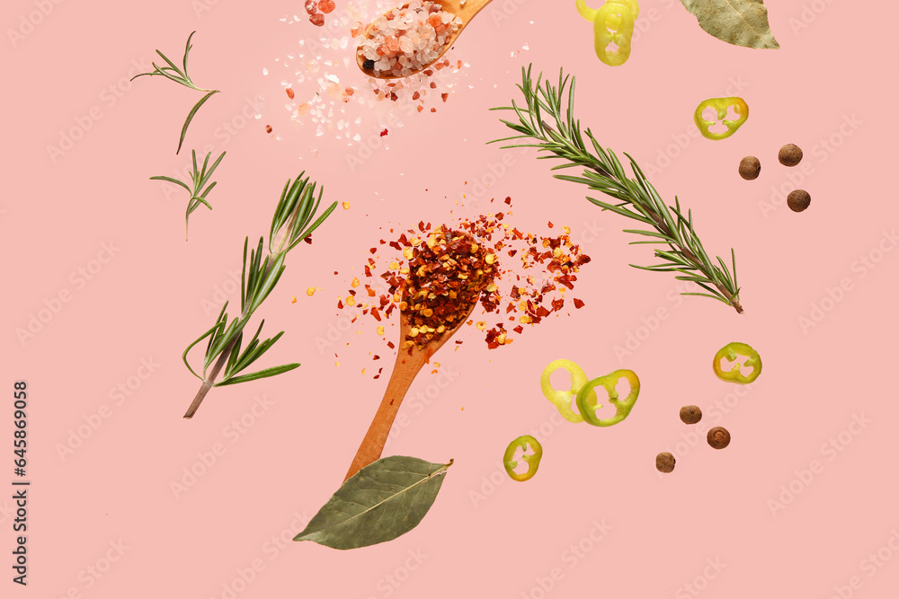 Flying spices and herbs on pink background