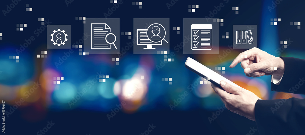 Document management system concept with businessman using a tablet computer at night