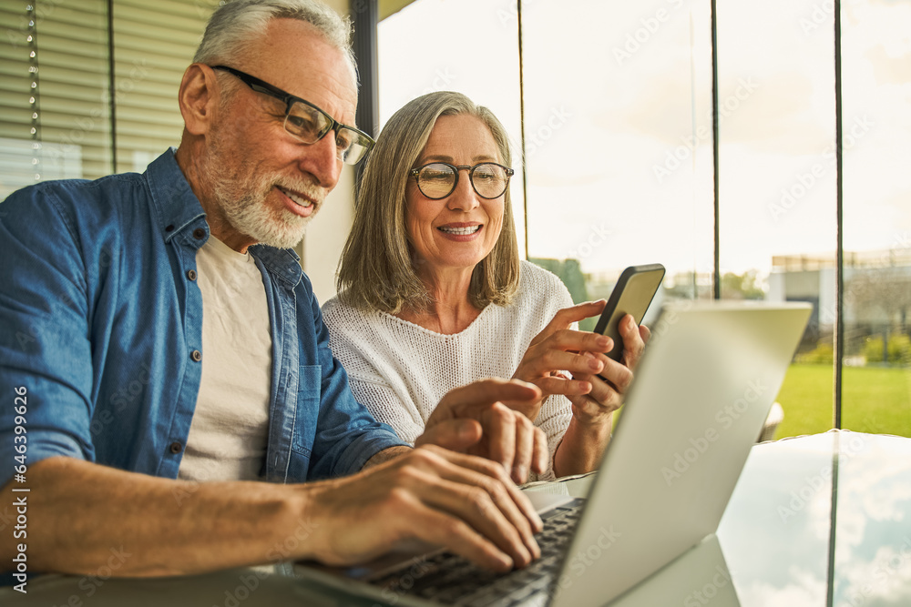 Man is typing computer while woman is looking at screen with interest