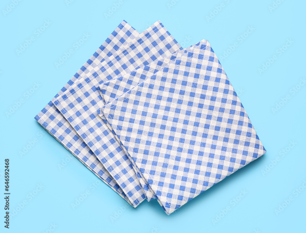 Set of checkered napkins on color background