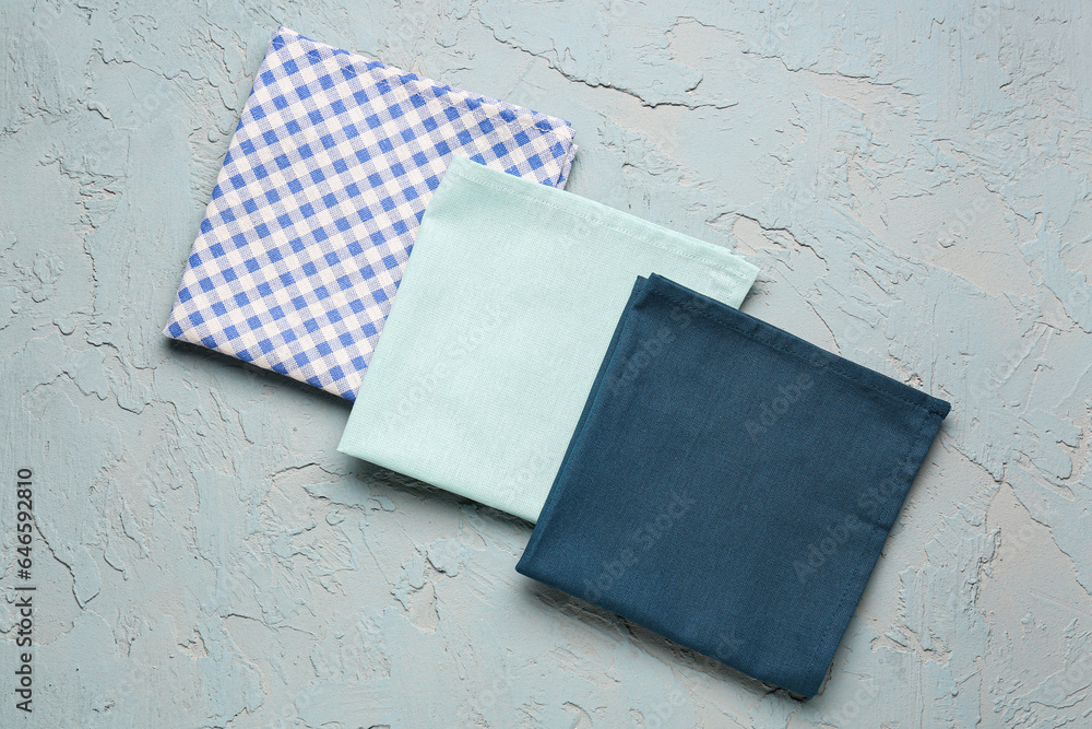 Set of clean folded napkins on color background