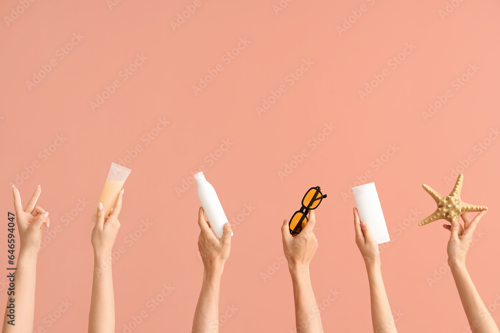 Female hands with bottles of sunscreen cream, sunglasses and starfish on color background