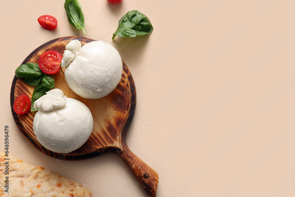 Wooden board of tasty Burrata cheese with basil and tomatoes on beige background