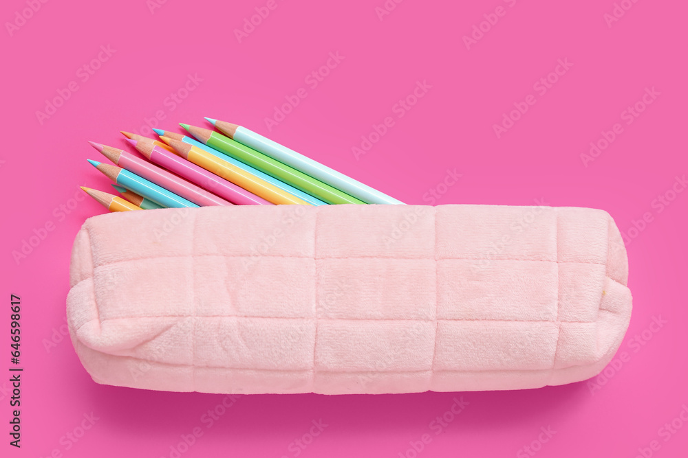 Case with colorful pencils on pink background