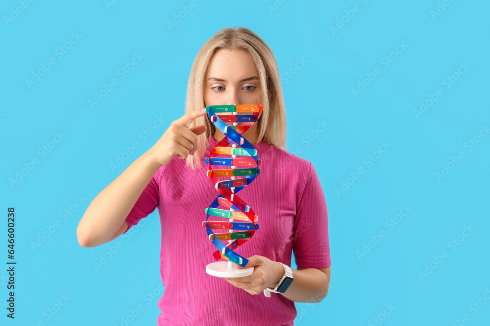 Thoughtful young beautiful woman with molecular model on blue background