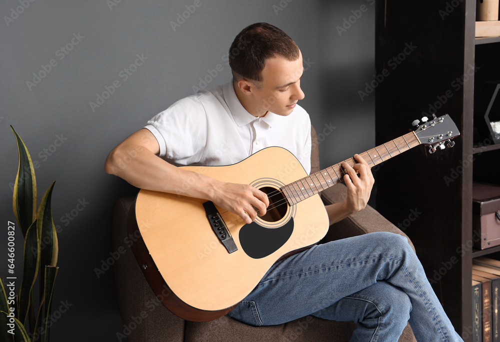 Young man playing guitar at home