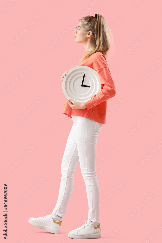 Young woman with clock on pink background. Deadline concept