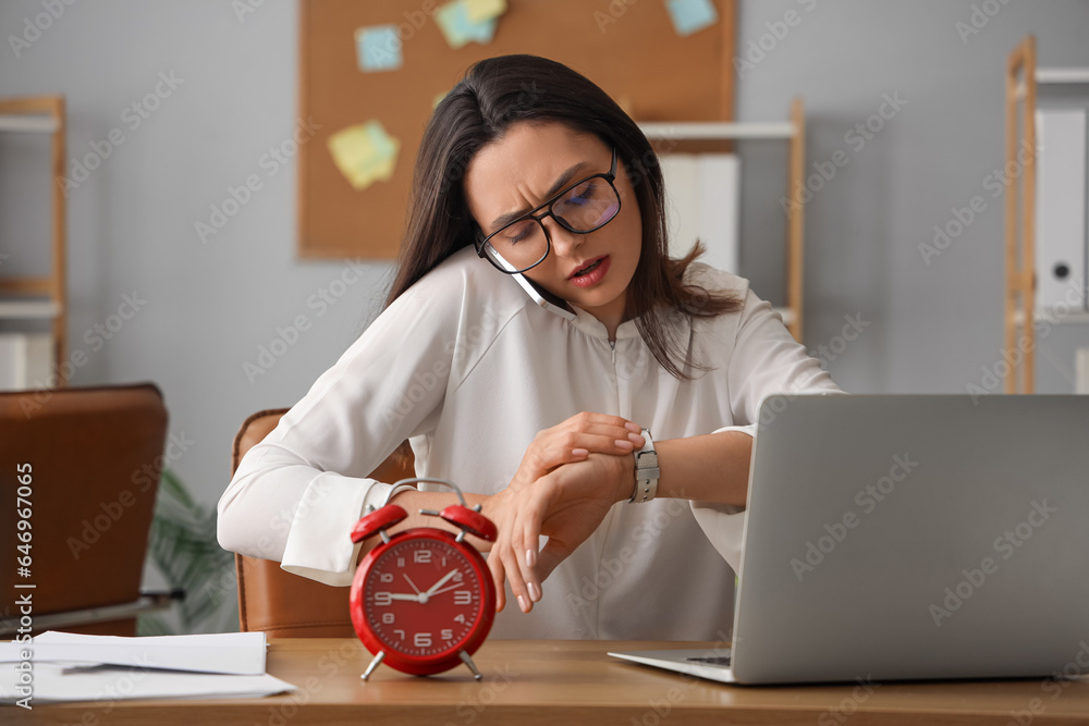 Stressed young businesswoman working under deadline in office