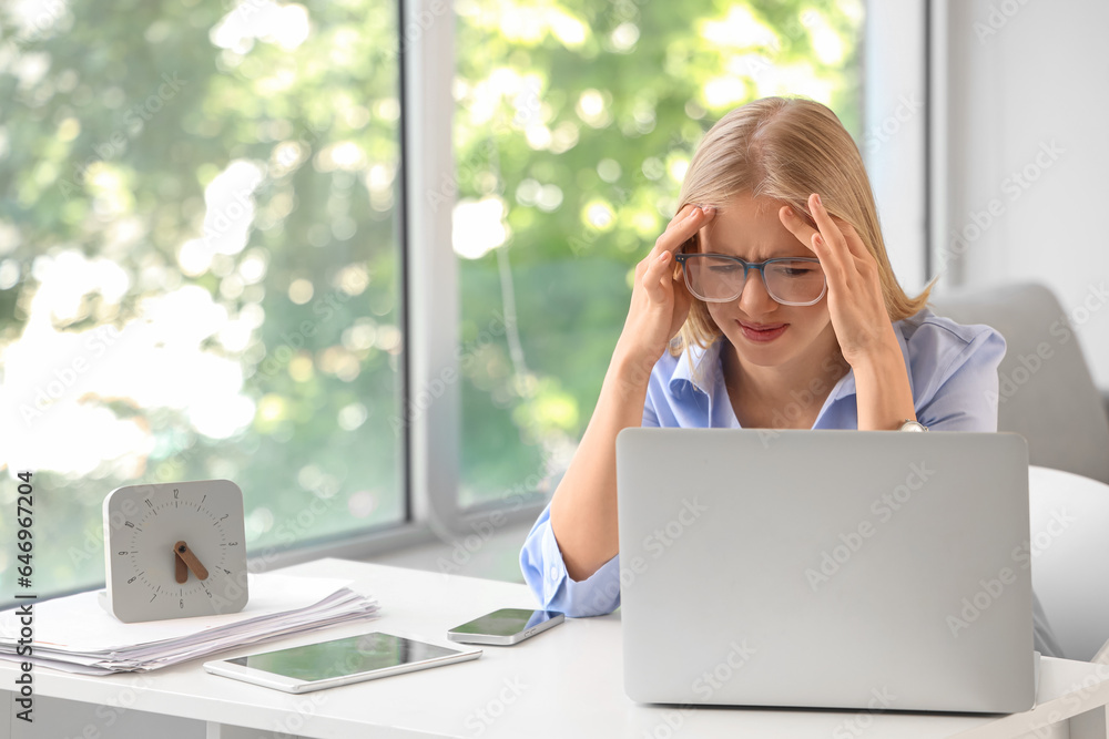 Stressed young businesswoman working under deadline in office