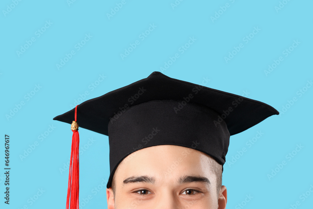 Male graduate student on blue background, closeup