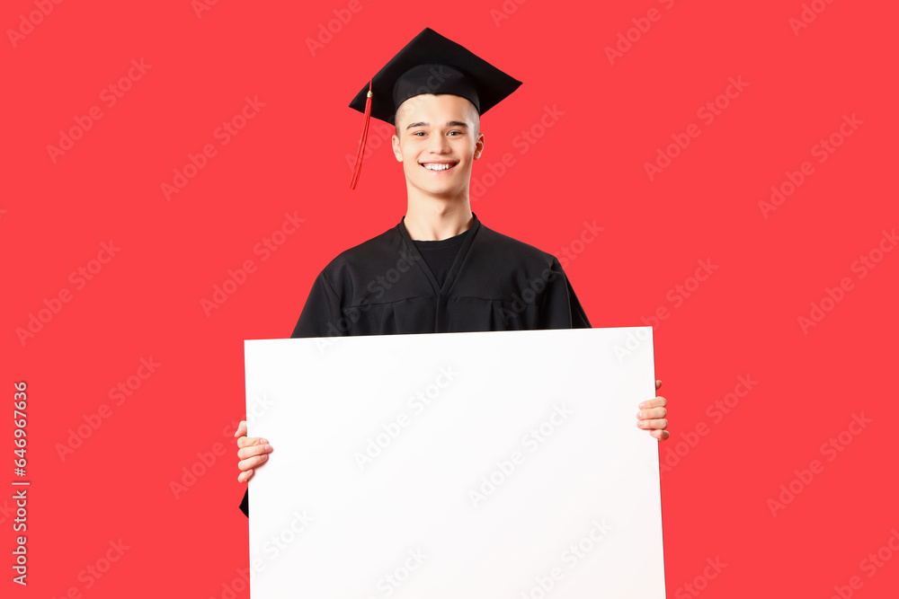 Male graduate student with blank poster on red background