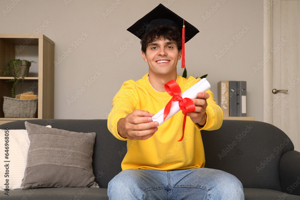 Male graduate student with diploma video chatting at home