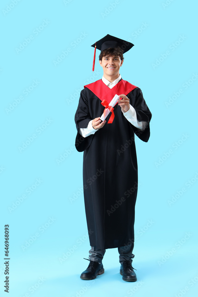 Male graduate student with diploma on blue background