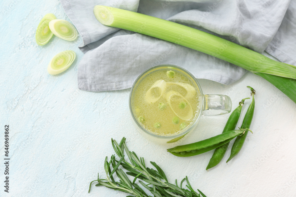 Glass cup of tasty vegetable broth on light background