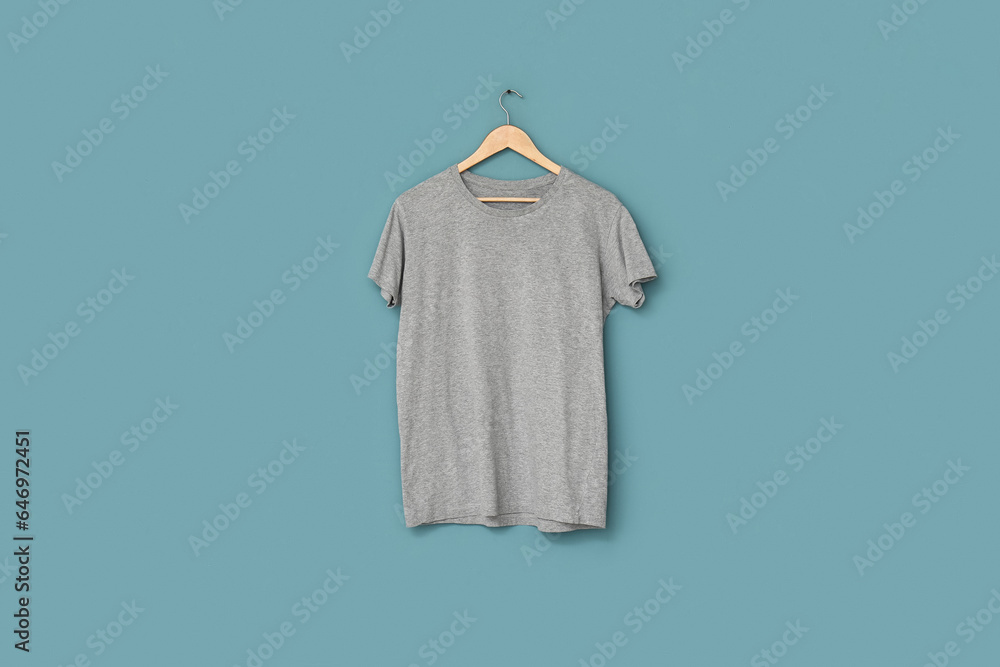 Stylish grey t-shirt hanging on blue background