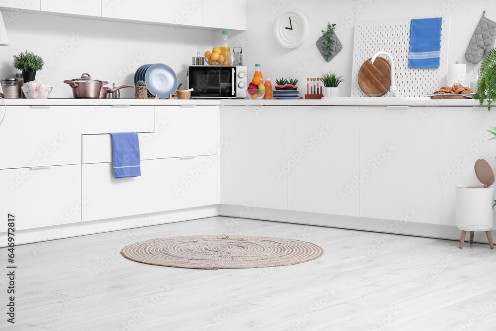 Stylish wicker rug on floor in modern kitchen